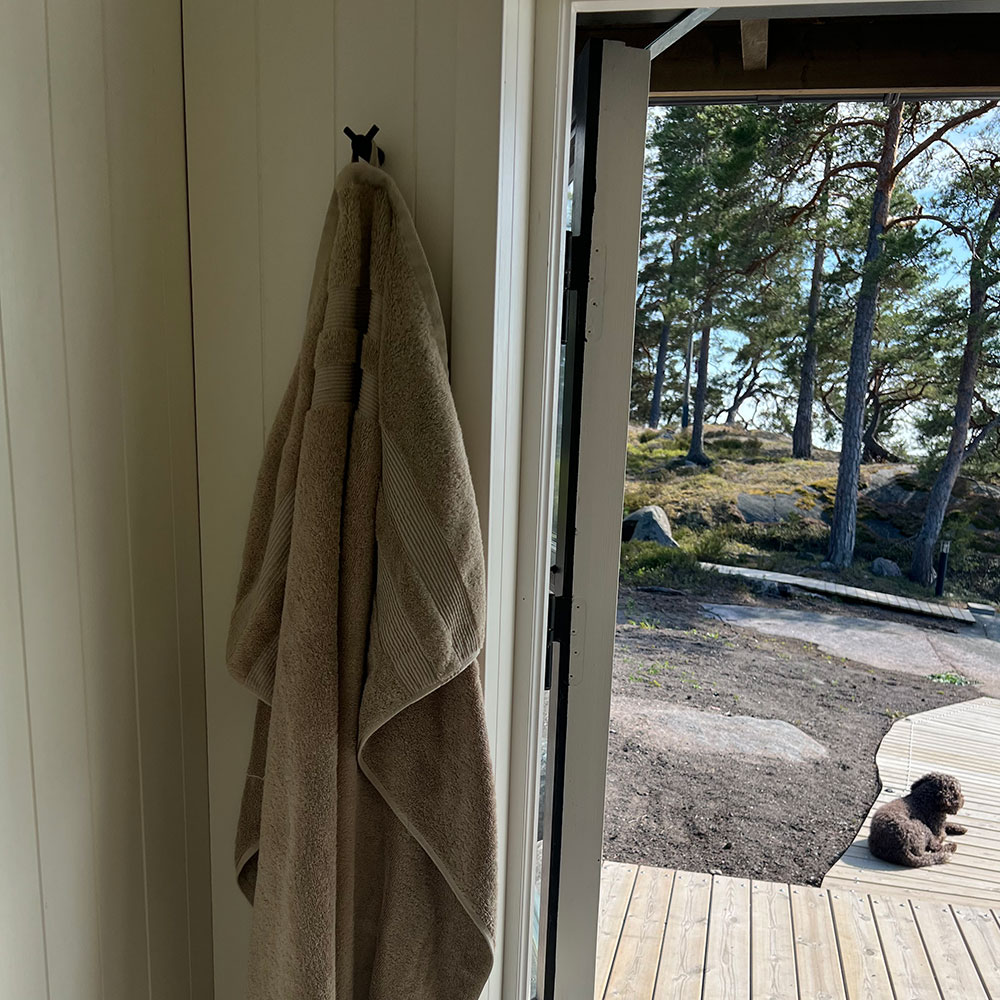 Jälkeen: saunan seinä mustilla kaksinkertaisilla Arc-koukuilla
